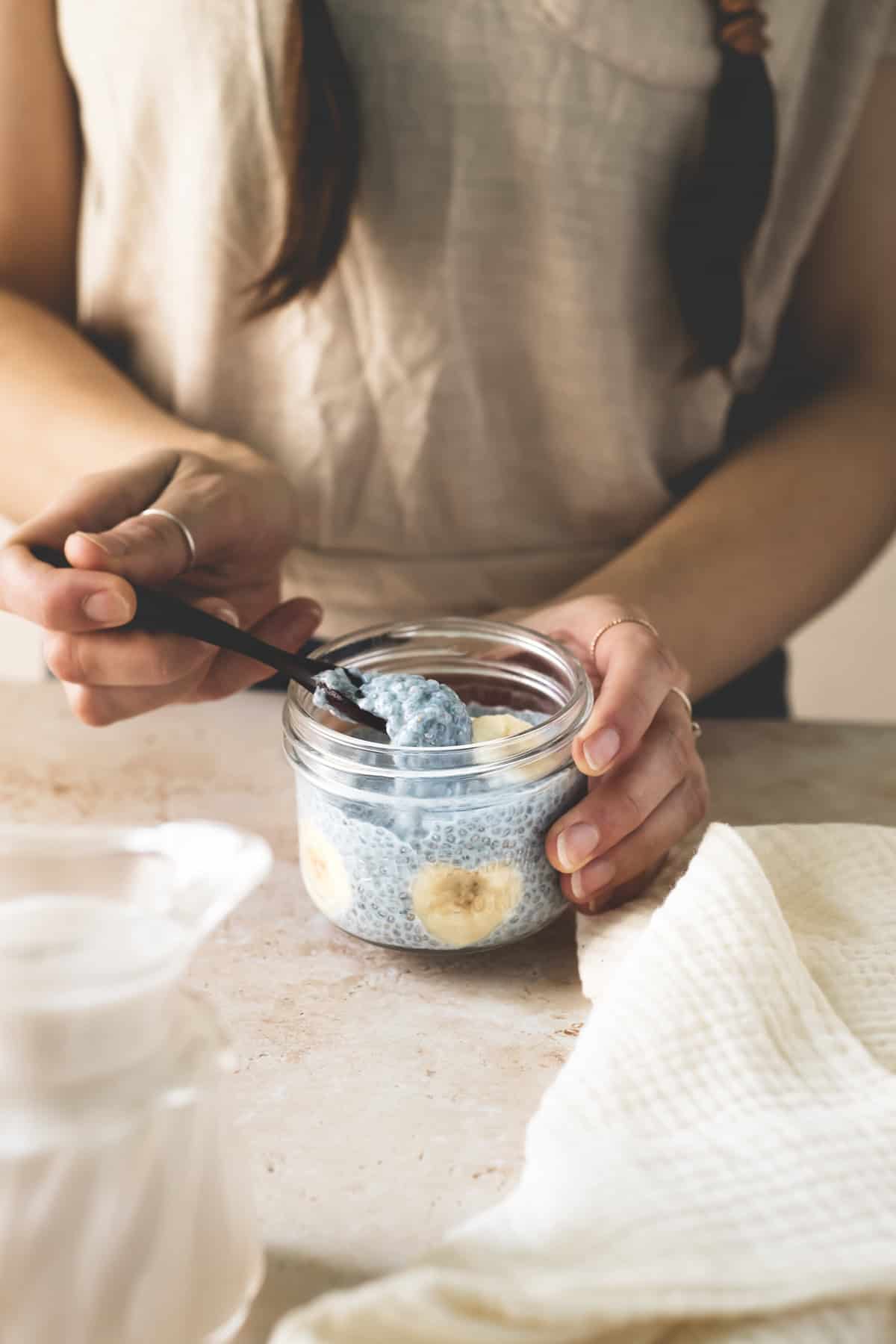 A spoonful of chia seed pudding being scooped out of a jar.